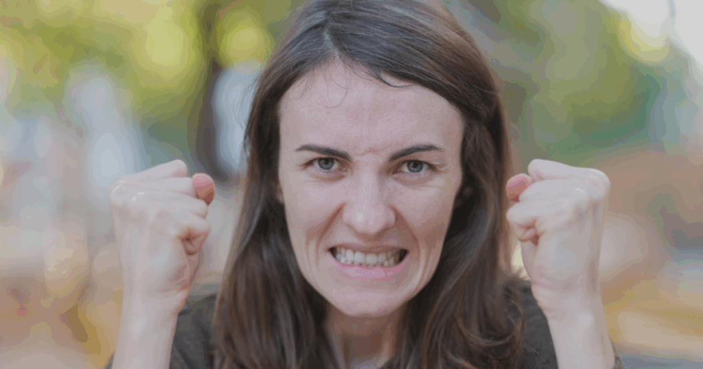 Wütende Frau mit geballten Fäusten – Symbolbild für emotionale Überforderung im Mama-Alltag.