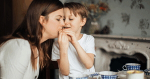 Mutter und Kind teilen liebevoll einen Snack – Symbol für Nähe, aber auch für den Balanceakt zwischen Fürsorge und eigener Identität.